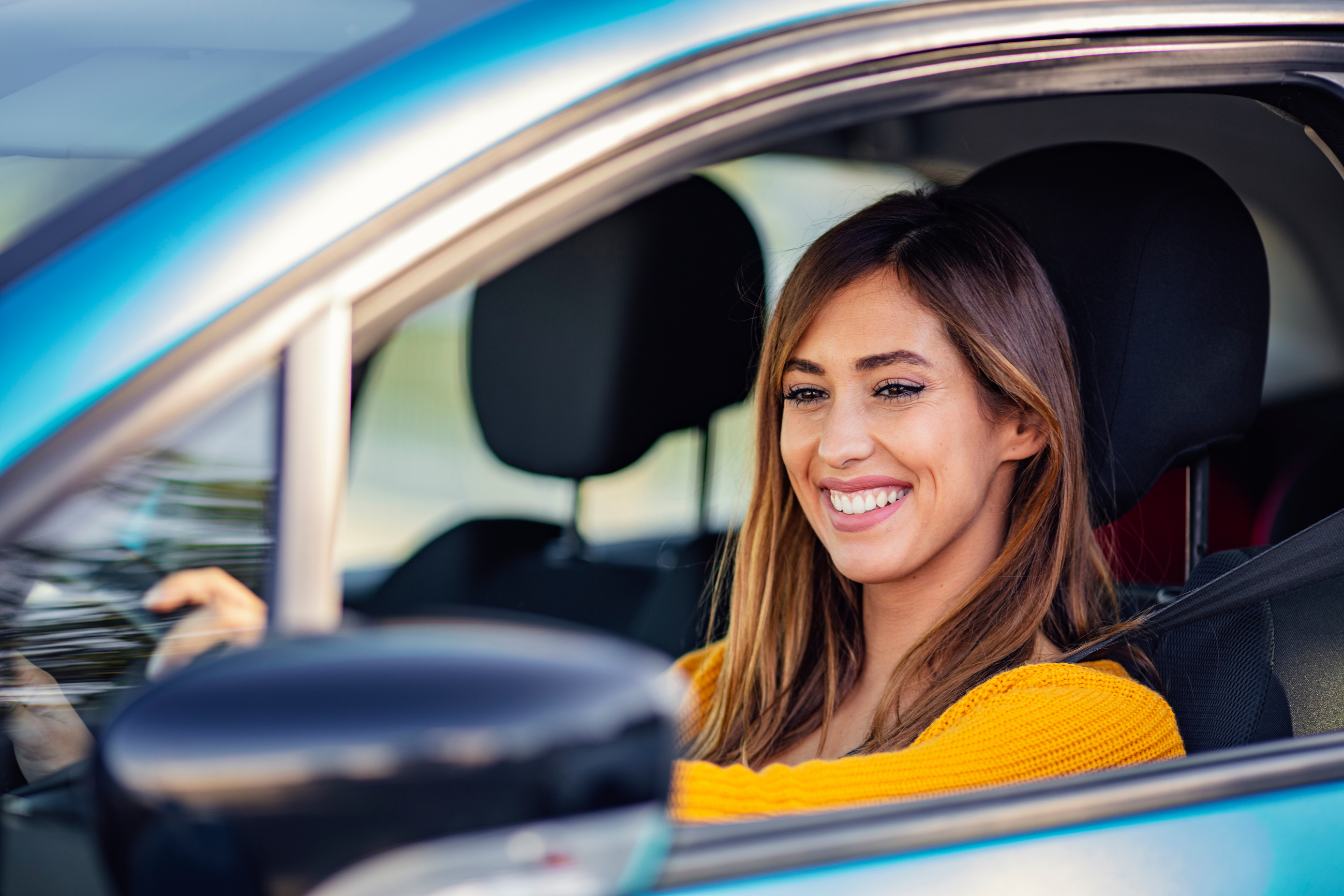 Cute young lady happy driving car.